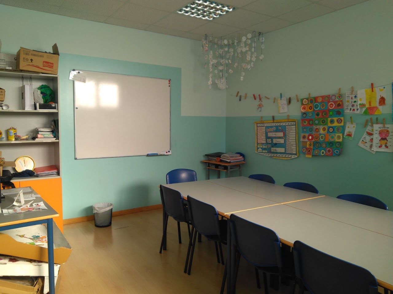 Aula de los pequeños, con pizarra y dibujos de los alumnos colgados en la pared