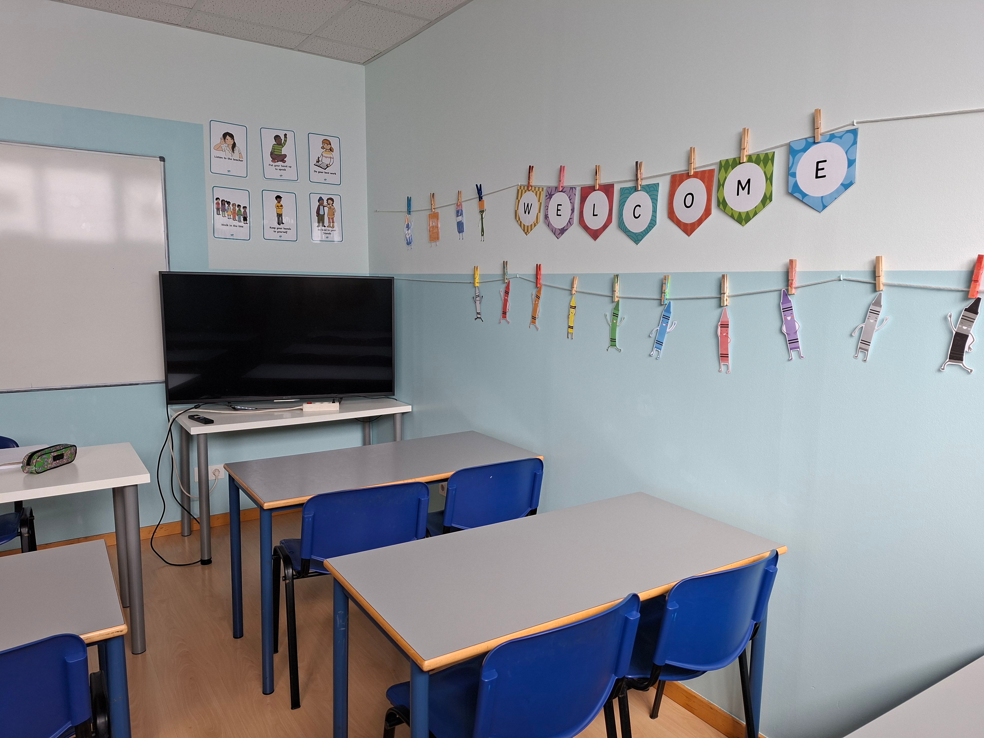 Aula de inglés con los meses del año y dibujos de los alumnos colgados en la pared