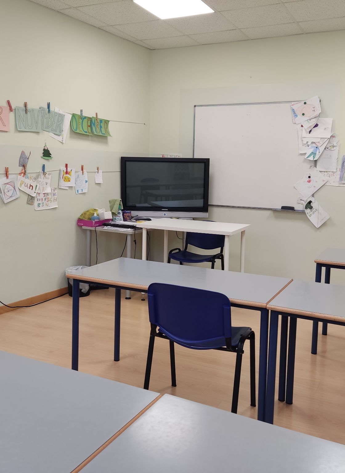 Aula de inglés con los meses del año y dibujos de los alumnos colgados en la pared